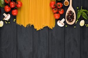 su uno sfondo scuro ingredienti ben disposti per il piatto. concetto di cucina italiana, copia spazio. foto