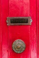 lettera scatola su il rosso porta con un antico maniglia foto