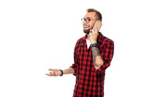 ritratto di un' casuale giovane uomo A proposito di su il Telefono e sorridente mentre guardare lontano, da qualche parte su. studio tiro su bianca sfondo foto