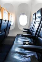 interni dell'aereo - cabina con moderna sedia in pelle per passeggeri di aereo. sedili e finestrino dell'aereo. - immagine verticale foto
