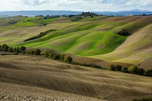 raccolto i campi e prati paesaggio nel Toscana, Italia. ondulato nazione scenario a autunno tramonto. arabile terra pronto per il agricolo stagione. foto