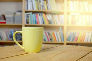 giallo boccale su un' di legno tavolo nel il biblioteca. copia spazio. disconnesso apprendimento concetto foto