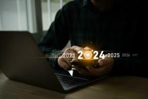 tendenze 2024 anno concetto. uomo utilizzando mobile il computer portatile e mostrando virtuale sequenza contare giù anni 2024 formulazione per marketing tenere sotto controllo e attività commerciale pianificazione nel nuovo anno. tecnologia nuovo anno concetto. foto