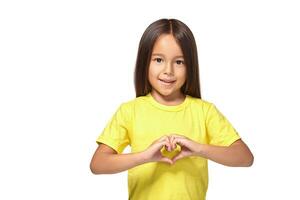 poco ragazza con sua mani nel a forma di cuore foto