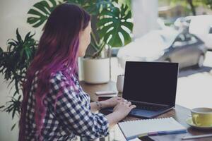 indietro Visualizza di un' giovane rosa capelli donna tastiera su il computer portatile comp foto