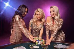 bellissimo ragazze con un' Perfetto acconciature e luminosa trucco siamo in posa in piedi a un' gioco d'azzardo tavolo. casinò, poker. foto