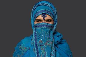 studio tiro di un' giovane bellissimo donna indossare il blu hijab decorato con paillettes e gioielleria. Arabo stile. foto