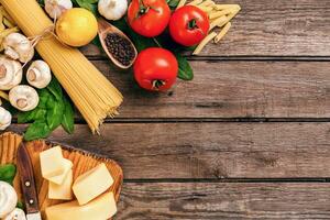italiano cibo pomodori da cucina, basilico, pasta, oliva olio e formaggio su di legno sfondo, superiore Visualizza, copia spazio. foto