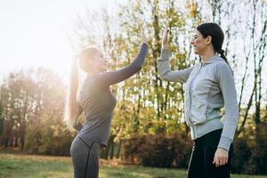 ragazze che si danno il cinque a vicenda mentre si allenano all'aperto foto