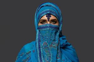 studio tiro di un' giovane bellissimo donna indossare il blu hijab decorato con paillettes e gioielleria. Arabo stile. foto