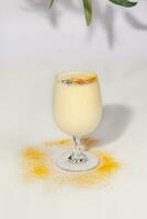 fruttato lassi con Yogurt e Mango polpa cosparso con Curcuma polvere foto