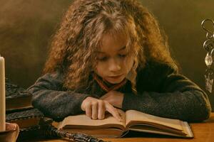 poco strega vestito nel buio Abiti seduta a il tavolo contro nero fumoso sfondo e lettura un' libro. avvicinamento ritratto. foto