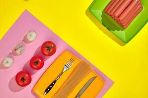 un' lotto di crudo salsicce su piatto. su giallo sfondo con pasta e la verdura, superiore Visualizza. foto