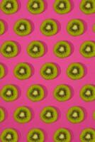 modello di Kiwi. superiore Visualizza di il affettato Kiwi su rosa sfondo. minimo piatto posare concetto. foto