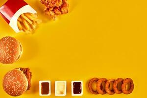 superiore Visualizza Hamburger, francese patatine fritte e fritte pollo su giallo sfondo. copia spazio per il tuo testo. foto