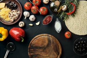 taglio di legno tavola con tradizionale Pizza preparazione ingredienti formaggio, pomodori salsa, basilico, oliva olio, Pepe, spezie. nero struttura tavolo sfondo foto