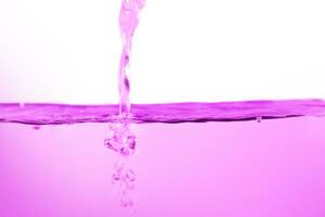 rosa acqua superficie con spruzzi e bolle su bianca sfondo. foto