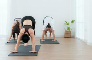 gruppo di persone praticante yoga nel un' studio. yoga classe concetto. foto