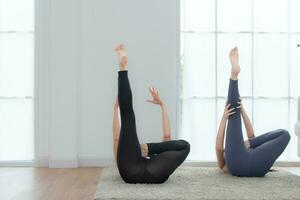 Due giovane donna praticante yoga con istruttore nel Casa. individuale yoga classe praticante nel Casa foto