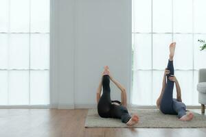 Due giovane donna praticante yoga con istruttore nel Casa. individuale yoga classe praticante nel Casa foto