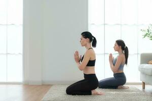 giovane donna praticante yoga con istruttore nel Casa. individuale yoga classe praticante nel Casa foto