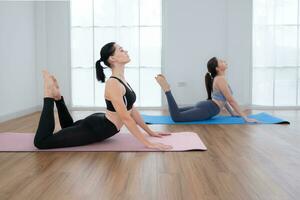 giovane donna praticante yoga con istruttore nel Casa. individuale yoga classe praticante nel Casa foto