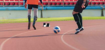 calcio giocatore calciando il palla su il traccia nel il stadio con Disabilitato atleti formazione sessioni. foto