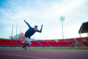 Disabilitato atleti preparare nel di partenza posizione pronto per correre su stadio traccia foto