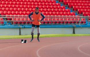 Disabilitato atleti preparare nel di partenza posizione pronto per correre su stadio traccia foto