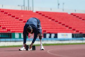 Disabilitato atleti preparare nel di partenza posizione pronto per correre su stadio traccia foto