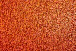 un arancia metallo superficie con un' pochi piccolo macchie foto