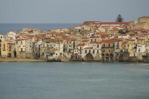 case lungo il litorale e Cattedrale nel sfondo, cefalù, sicilia foto