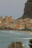 case lungo il litorale e Cattedrale nel sfondo, cefalù, sicilia foto