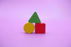 impostato di colorato di legno forma giocattolo. quadrato, triangolo e il giro su viola sfondo foto