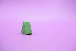 verde di legno forma giocattolo. triangolo su viola sfondo foto