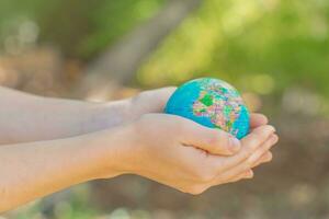 umano mani Tenere globale terra sfera. sostenere terra concetto. amore natura. Salva il pianeta. foto