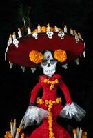 mestiere di catrina vestito elegantemente con cempasuchil fiori e candele per il giorno di il morto foto