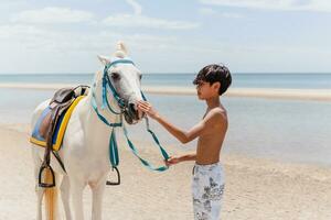 giovane ciclista con cavallo in piedi su il spiaggia. foto