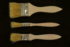 tre diverso tipi di dipingere spazzole su un' nero sfondo foto