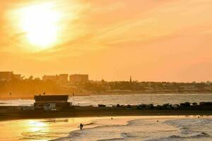 un' spiaggia con un' tramonto nel il sfondo foto