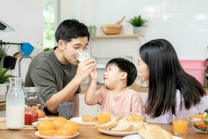 famiglia volta, colazione, attività insieme durante il vacanze. genitori e bambini siamo avendo un' pasto insieme durante il vacanze. nuovo casa per famiglia su mattina, divertiti, fine settimana, vacante tempo foto