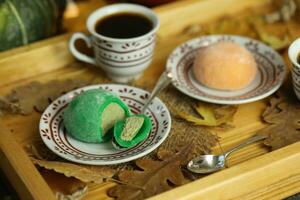 colorato giapponese dolci daifuku o mochi affettato. dolci vicino su su il piatto con tazza di caffè foto