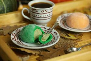 colorato giapponese dolci daifuku o mochi affettato. dolci vicino su su il piatto con tazza di caffè foto