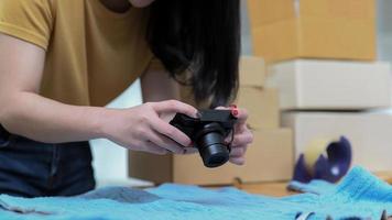 giovane donna utilizza una fotocamera per scattare foto di prodotti per pubblicarli in vendita online.