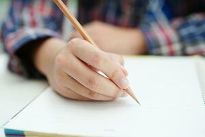 asiatico adolescenziale alunno Scrivi compiti a casa, studia lezione per esame in linea apprendimento formazione scolastica. foto