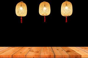prospettiva di legno tavola al di sopra di nero sfondo e sospeso lampada foto