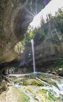 bella cascata bocca di un drago e bagliori del sole, krasnaya polyana, sochi, russia. foto