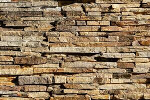 sfondo di pietra parete struttura. il superficie di il pietre è Marrone foto