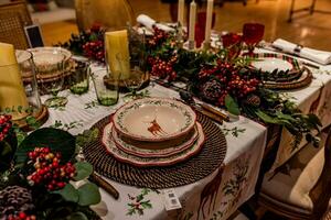 impostato Natale tavolo con piatti e bicchieri foto