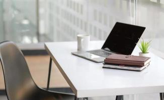 colpo ritagliato di notebook e laptop sulla scrivania in un ufficio moderno.